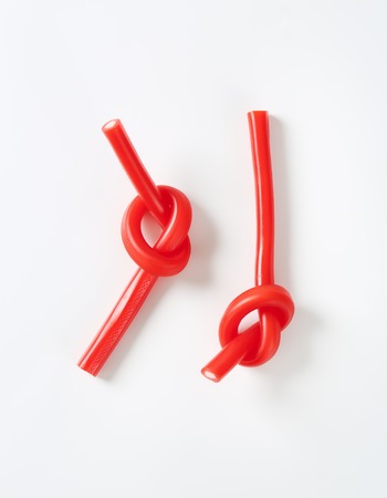 knotted soft strawberry candy sticks on white backgroundの写真素材