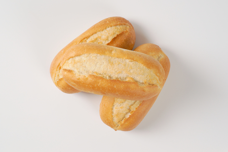 three freshly baked mini baguettes on white backgroundの写真素材