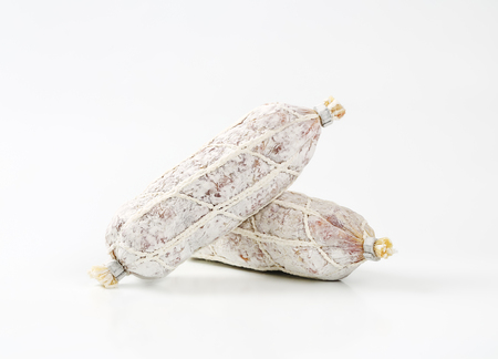 two French dry cured sausages on white backgroundの写真素材