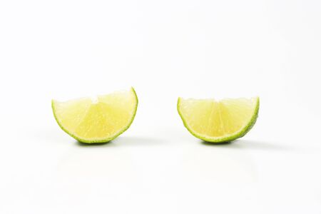 two slices of fresh lime on white backgroundの写真素材