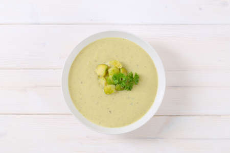 plate of vegetable soup with Brussels sprouts on white backgroundの写真素材