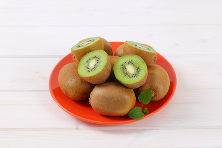 plate of whole and halved kiwi fruitsの写真素材