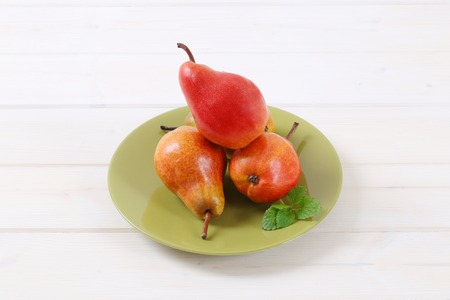 plate of ripe red pears on white backgroundの写真素材