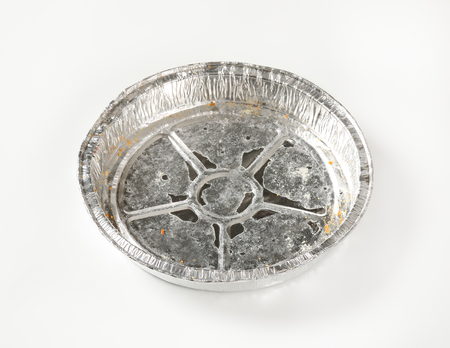 Used round tin foil cake pan on white backgroundの写真素材