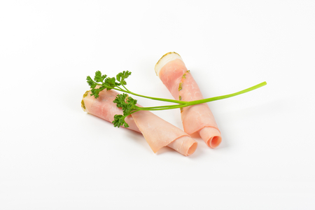 slices of asparagus coated ham rolled on white backgroundの写真素材