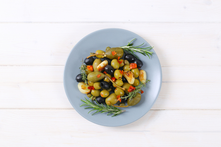 Plate of green and black olives with garlic, capers and caper berriesの写真素材
