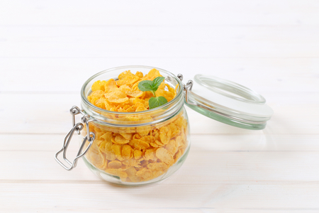 jar of corn flakes on white background