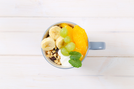 cup of muesli with yogurt and fresh fruit on white backgroundの写真素材