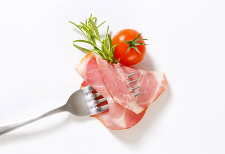 Slice of smoked pork on forkの写真素材