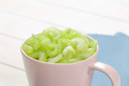 cup of chopped celery stems on blue place mat - close upの写真素材