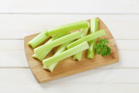 stems of green celery on wooden cutting boardの写真素材