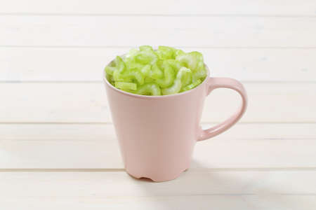 cup of chopped celery stems on white wooden backgroundの写真素材
