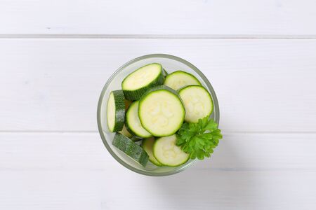 glass of green zucchini slices on white wooden backgroundの写真素材