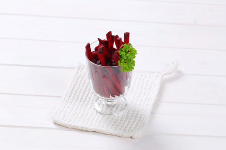 glass of beetroot strips on white table matの写真素材