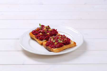 toast with beetroot spread on white plateの写真素材
