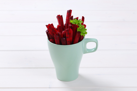 cup of beetroot strips on white wooden backgroundの写真素材