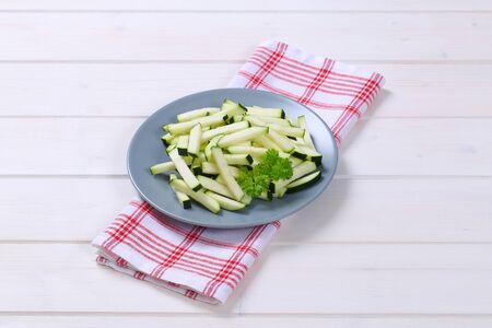 plate of zucchini strips on checkered dishtowelの写真素材