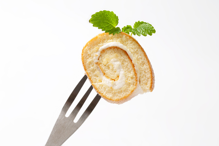 Slice of sweet creamy roll on a forkの写真素材