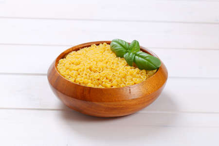 bowl of small pasta shells on white wooden backgroundの写真素材