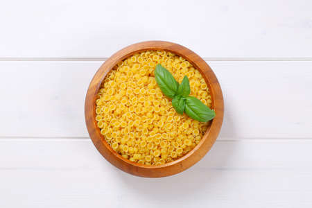 bowl of small pasta shells on white wooden backgroundの写真素材