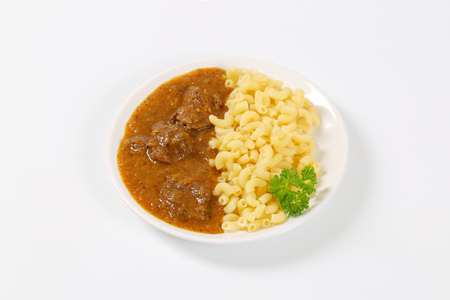 plate of beef goulash with cooked macaroniの写真素材