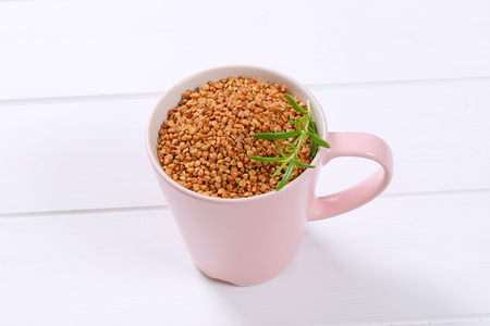 cup of raw buckwheat on white wooden backgroundの写真素材