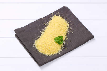 pile of raw couscous on grey place matの写真素材