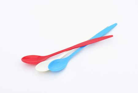 Three empty long plastic spoons - red, blue and whiteの写真素材