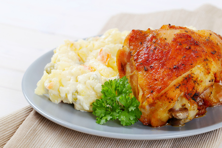 roasted chicken with potato salad on grey plate - close upの写真素材