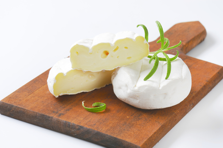 soft cheese with white rind on wooden cutting board - close upの写真素材