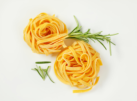 bundles of dried ribbon pasta on white backgroundの写真素材