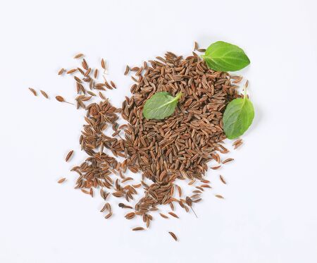 handful of caraway seeds on white background