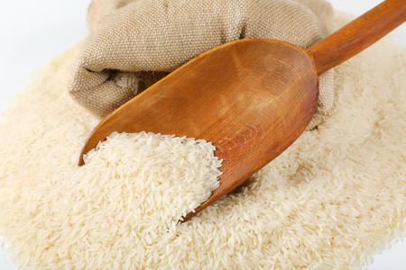 pile of long grained rice, wooden scoop and burlap bag - close upの写真素材