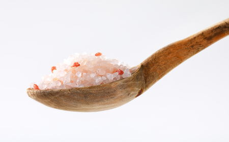 spoon of coarse grained Himalayan salt on white backgroundの写真素材