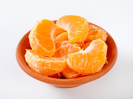 bowl of fresh tangerine slices on white backgroundの写真素材