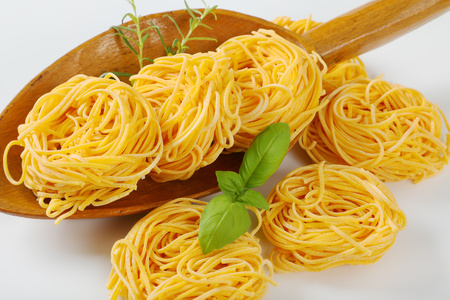 bundles of spaghetti pasta and herbs in wooden scoop - close upの写真素材