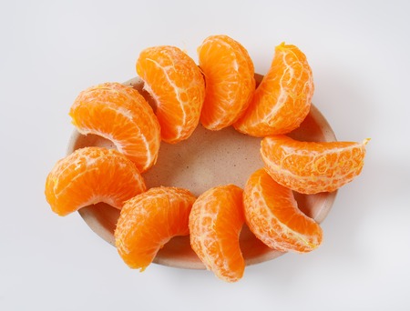 plate of fresh tangerine slices on white backgroundの写真素材