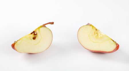 red apple wedges on white backgroundの写真素材
