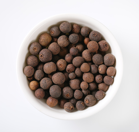 bowl of allspice berries on white backgroundの写真素材