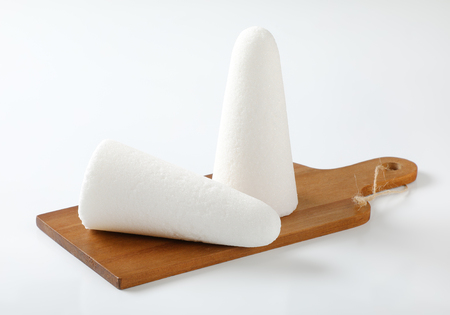 two white sugar loaves or cones on wooden cutting boardの写真素材