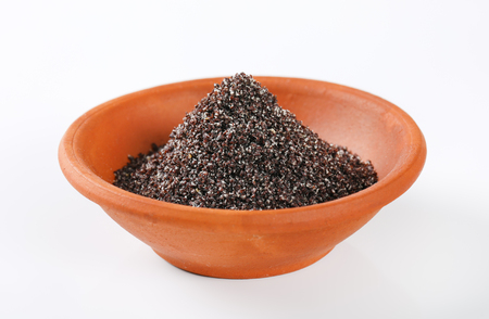 bowl of ground poppy seeds on white backgroundの写真素材