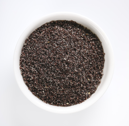 bowl of ground poppy seeds on white backgroundの写真素材