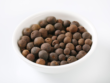 bowl of allspice berries on white backgroundの写真素材