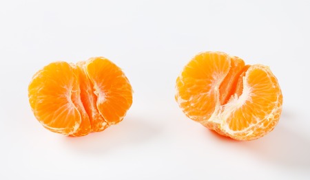 halved peeled tangerine on white backgroundの写真素材