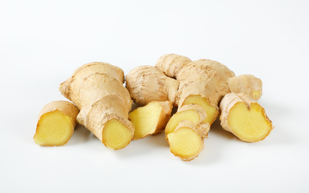 sliced ginger roots on white backgroundの写真素材