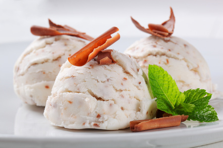 Scoops of stracciatella ice cream topped with chocolate shavingsの写真素材