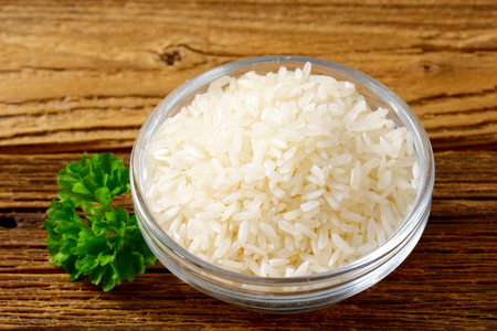 Rice in a bowl on wooden backgroundの写真素材