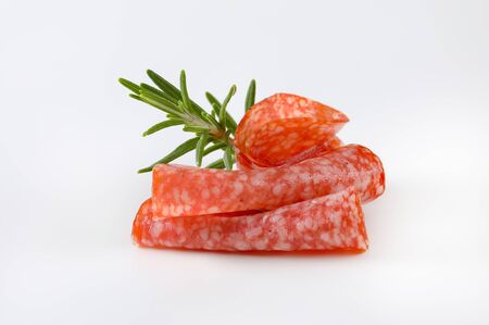 Thin slices of Hungarian salami and fresh rosemaryの写真素材