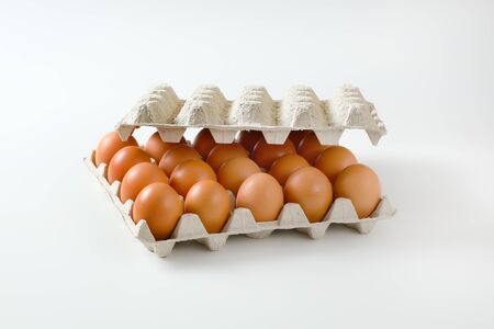 Twenty fresh brown eggs in a paper egg trayの写真素材