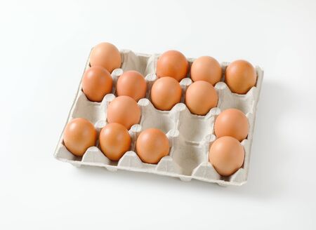 Fresh brown eggs in a twenty dimpled egg trayの写真素材